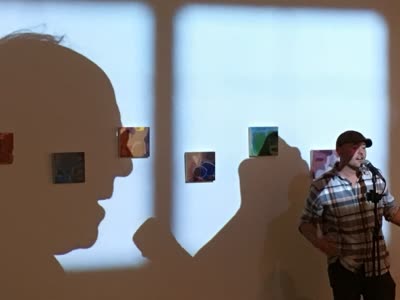 Reading in front of a projected silhouette of Bernie Sanders, 18 April 2016.