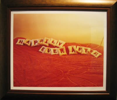 Framed photograph, letters on a red bedspread.