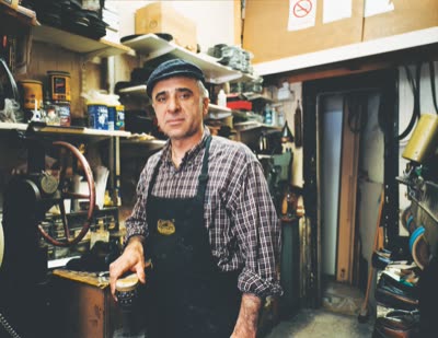 Lindsay Blatt, from Repair & Shine: shoe repairman at his counter, 2008, large-format photograph.