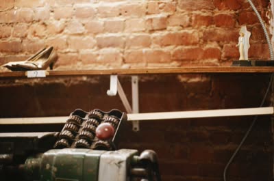Lindsay Blatt, from Repair & Shine: shoes on a shelf above a finishing machine, 2008, large-format photograph.