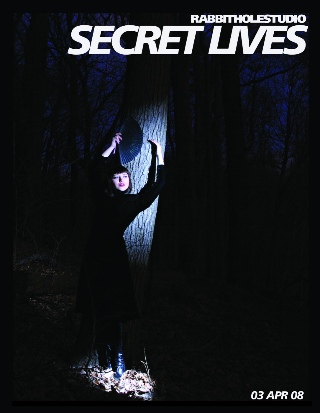 Card for Secret Lives: a woman in black holding a fan against a lit tree trunk in a dark forest (image by Ebru Yildiz)